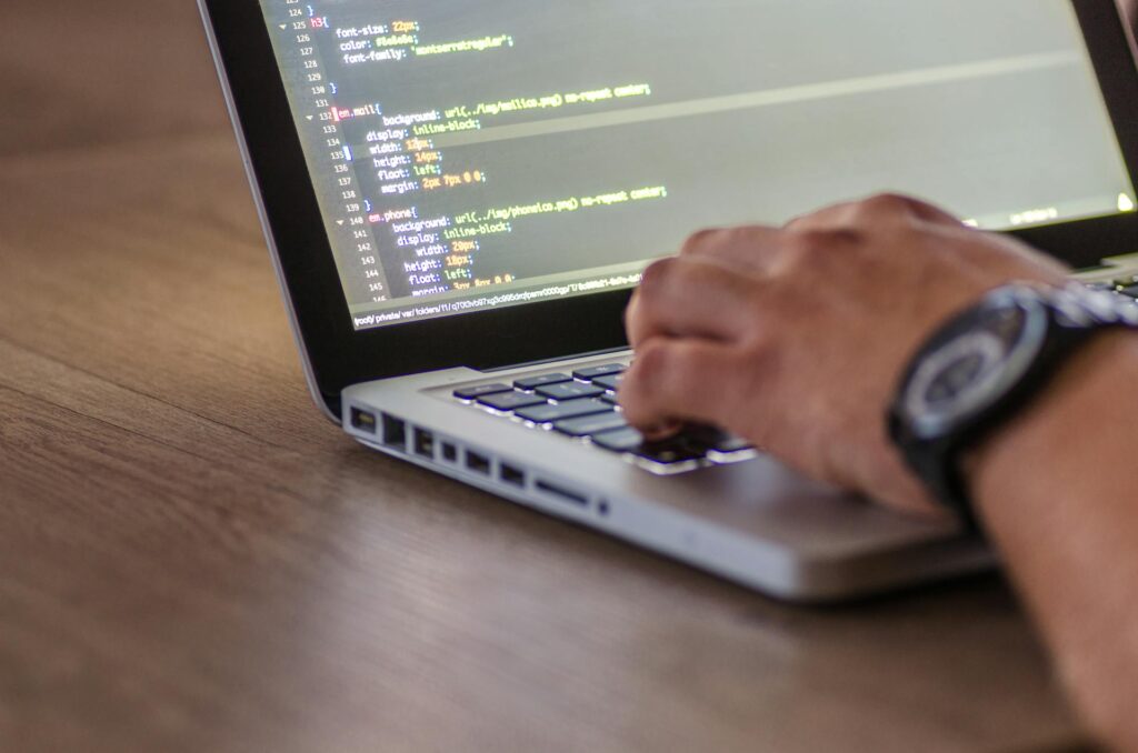 A person typing code on a laptop