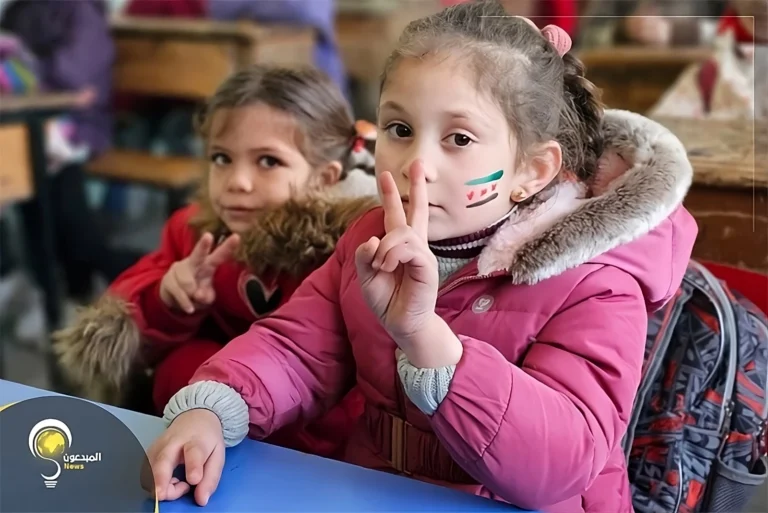 Syrian students in a school courtyard waving the new national flag, with some children smiling and holding flags painted on their cheeks