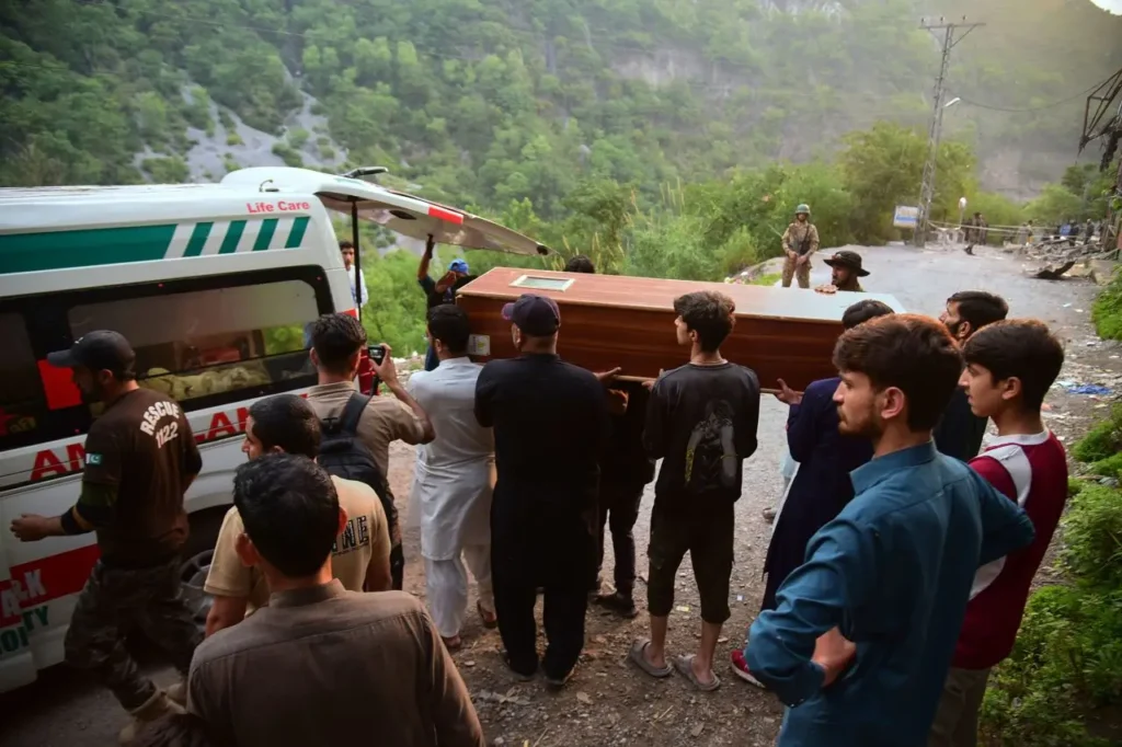 Volunteers carry a body from the rubble of a damaged mosque in Pakistan-administered Kashmir.