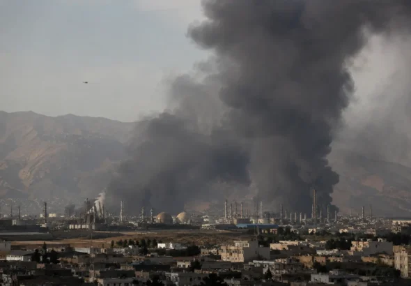 Massive black smoke rising from an industrial facility following a US-Israel air strike during the Iran Israel attack.